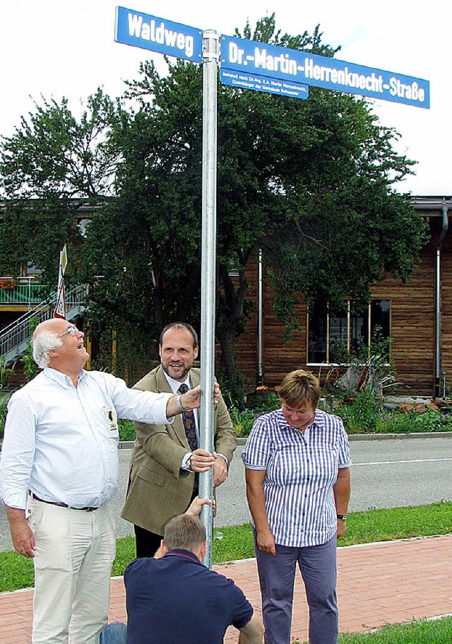 Haben gut lachen (v. li.): Martin Herr...pert montiert das neue Straenschild.   | Foto: bz