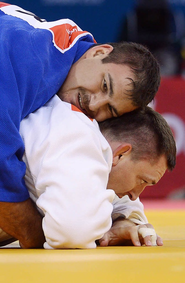 Andreas Tlzer (in Blau) hat Ihar Makarau fest im Griff.   | Foto: AFP