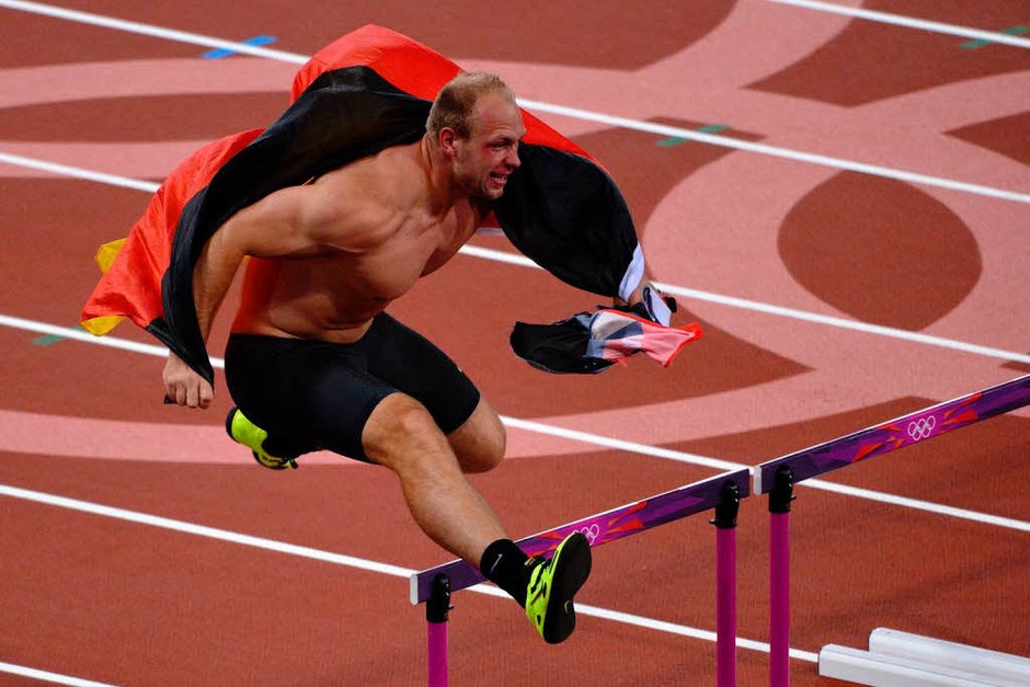 Olympiasieger! Nach seinem Goldwurf dreht Diskuswerfer Robert Harting eine Ehrenrunde im Stadion. Die Hindernisse des 100-Meter-Hürdenlaufs nimmt er gekonnt mit. (Foto: AFP) Olympiasieger! Nach seinem Goldwurf dreht Diskuswerfer Robert Harting eine Ehrenrunde im Stadion. Die Hindernisse des 100-Meter-Hürdenlaufs nimmt er gekonnt mit. (Foto: AFP)