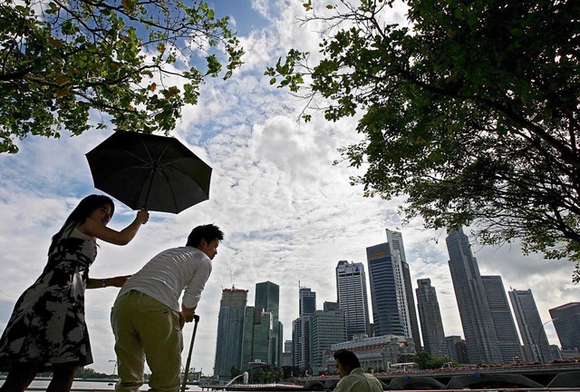 Touristen  vor den Hochhusern des Finanz- und Bankenviertels in Singapur   | Foto: dpa