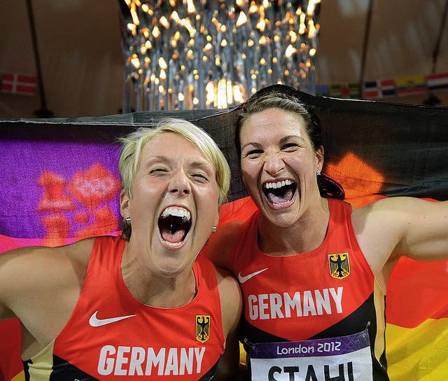 Christina Obergfll (links) und Linda ...and-Fahne vor der olympischen Flamme.   | Foto: dapd