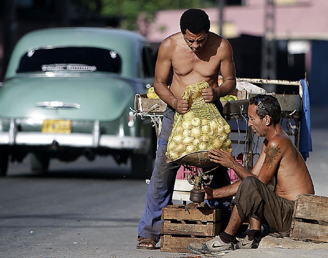 Zwei selbststndige Geschftsmnner  wiegen Zwiebeln, bevor sie sie verkaufen.   | Foto: dapd