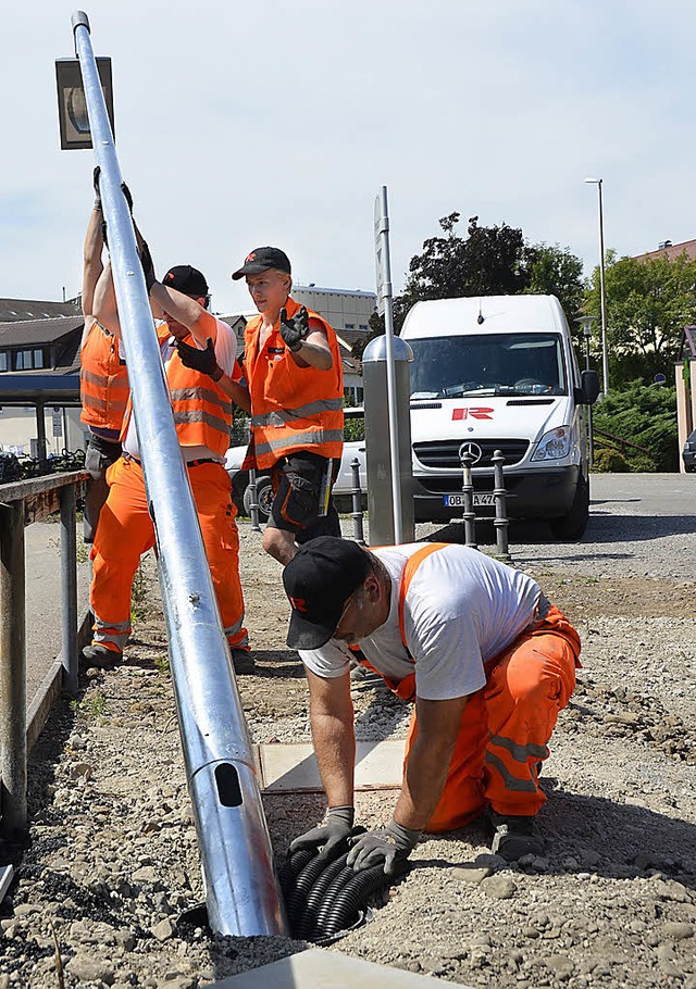 Reine Muskelkraft: Arbeiter richten einen Mast auf.   | Foto: Jens Klein