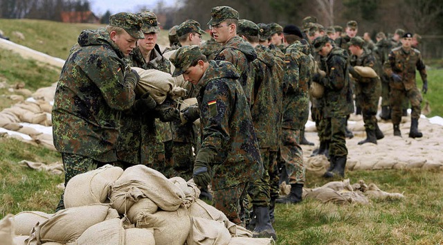 Soldaten sichern einen Deich mit Sands... im Inland auf den Katastrophenschutz.  | Foto: Dpa