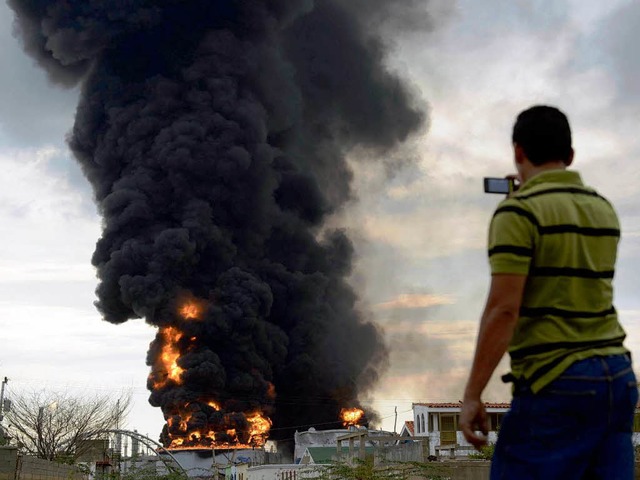 Traurige Erinnerung: Ein Mann fotografiert das Feuer in Amuay  | Foto: AFP