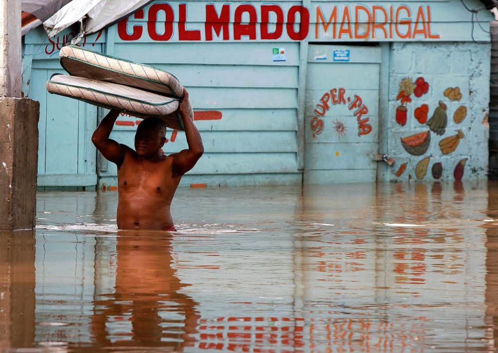 Ein Mann flchtet vor den Wassermassen im berschwemmten Santo Domingo. ber 25.000 Menschen mussten in Sicherheit gebracht werden.