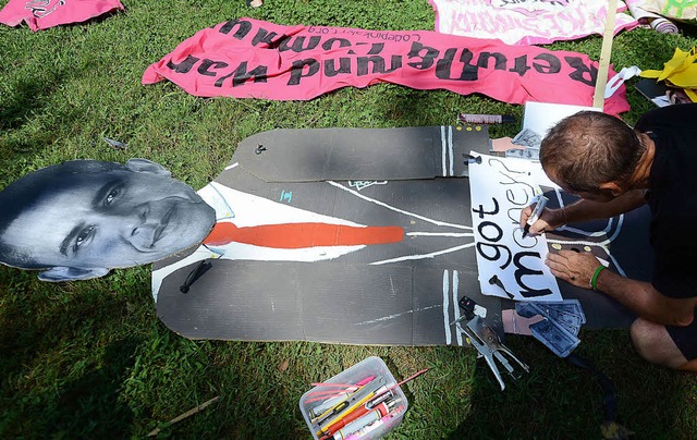 Vor dem Parteitag der Demokraten in Ch...n Mann ein Protestplakat gegen  Obama.  | Foto: AFP