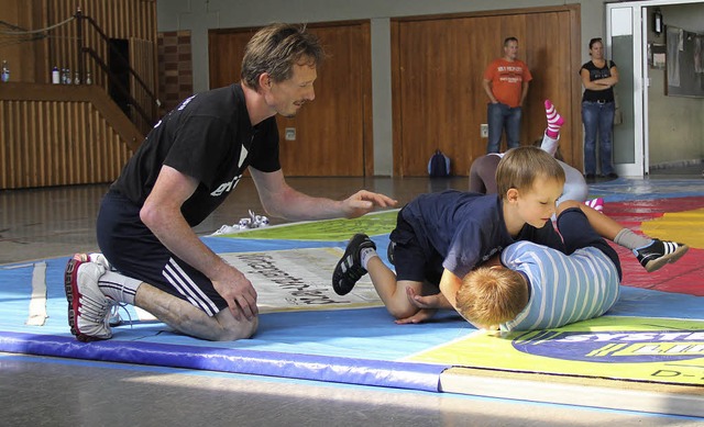 Reiner Kuder, Trainer bei den Ringern ...sen,  zeigt den Kindern erste Griffe.   | Foto: Monika Weber