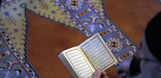 Ein Glubiger liest im Koran. Die trk...rkulturellen Woche in die Moschee ein.  | Foto: dpa