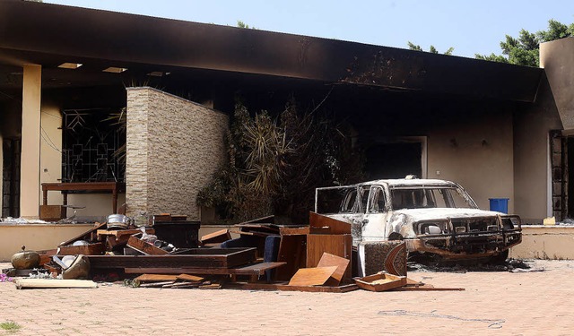 Ein ausgebranntes Auto steht vor der amerikanischen Botschaft in Bengasi.   | Foto: DAPD