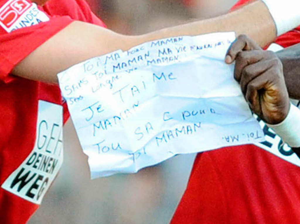 Diagne hlt einen Zettel mit der Aufschrift: "ich liebe Dich Mutti, das ist Alles fr Dich Mutti" in den Hnden.