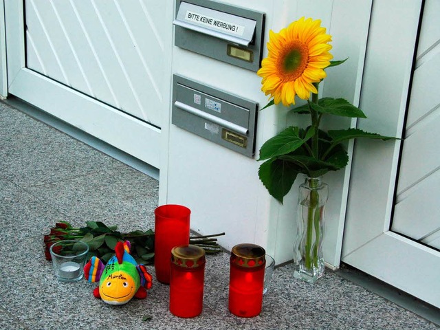 Ein Kuscheltier, Kerzen und Blumen vor der Haustr des getteten Jungen  | Foto: Martina proprenter