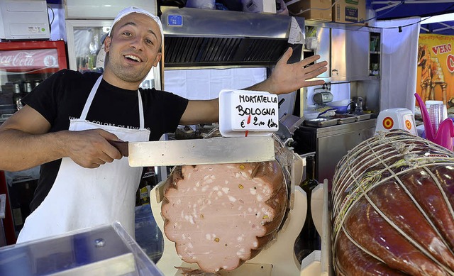 Daniele Galicchia schneidet eine Scheibe von der 50-Kilo-Mortadella.   | Foto: Ralf Burgmaier