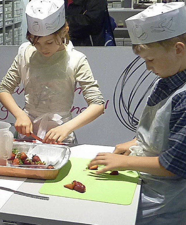 Erst die Arbeit, dann der Genuss: zwei Kursteilnehmer beim Erdbeerenschneiden   | Foto: s. Beck