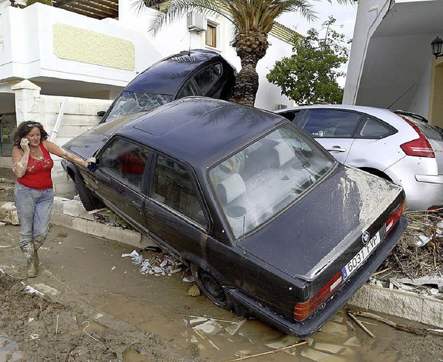 Mitgerissene Autos, vollgelaufene Hus...obadilla beginnt das groe Aufrumen.   | Foto: dpa/AFP