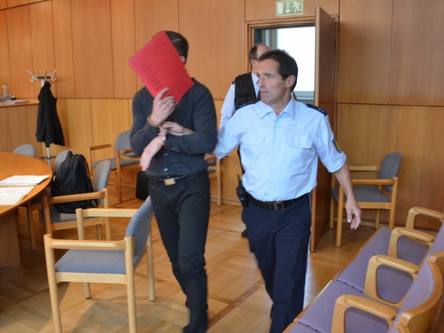 Der Angeklagte wird in Handschellen in den Gerichtssaal gefhrt.   | Foto: Ralf Burgmaier
