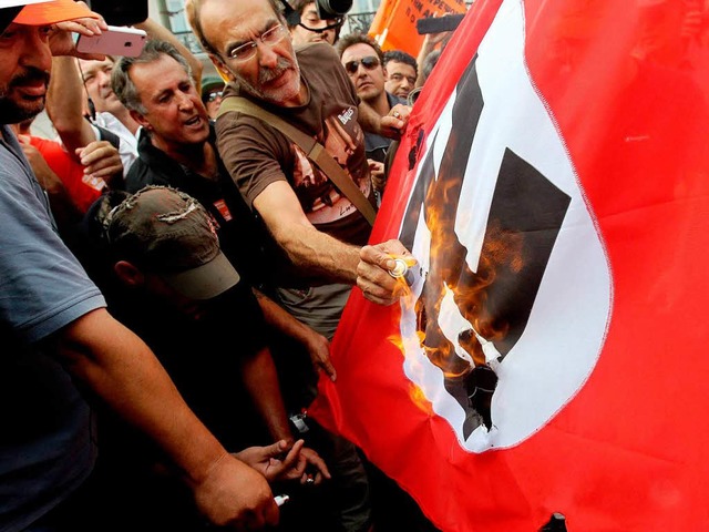 Demonstranten verbrennen eine Hakenkreuzfahne.  | Foto: dpa