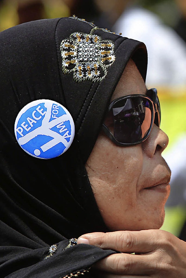 Muslima mit  Peace-Button an ihrem Kopftuch  | Foto: dpa