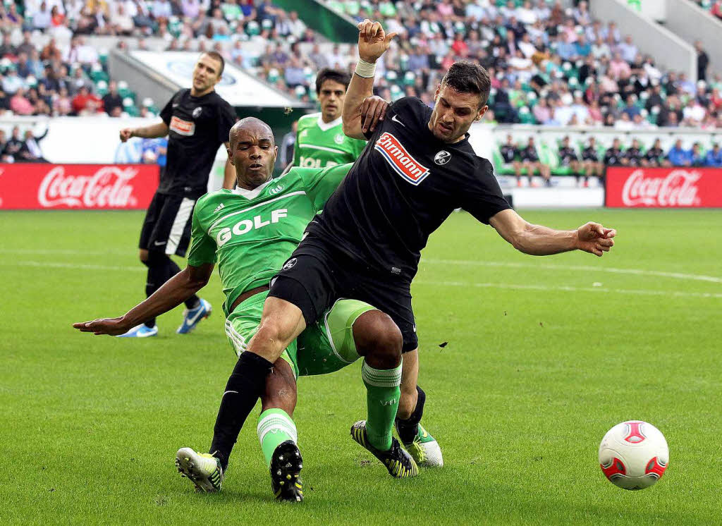 Wolfsburgs Naldo und Daniel Caligiuri (vorne) kmpfen um den Ball.
