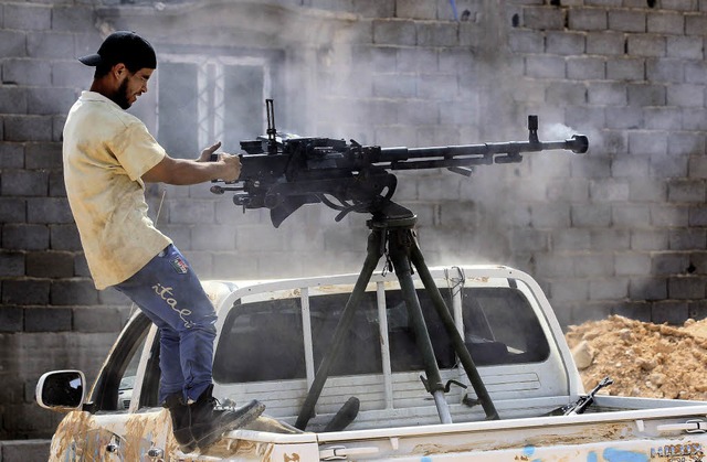 Ein libyscher Rebell  mit einem Maschi...em Kontrollpunkt im Sden von Tripolis  | Foto: dpa
