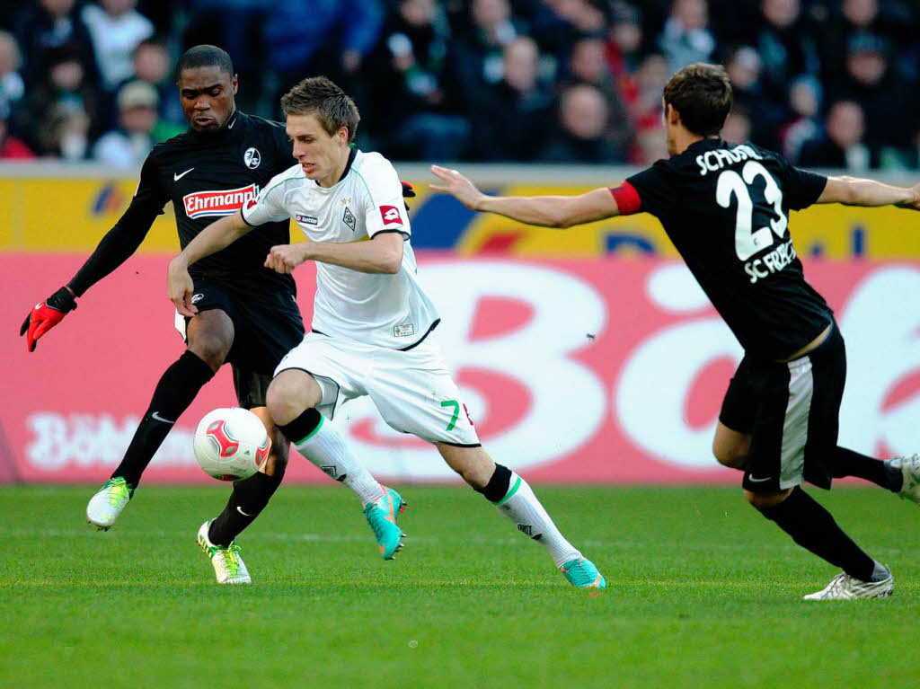 Patrick Herrmann setzt sich gegen die Freiburger Cedric Makiadi (l.) und Julian Schuster (r.) durch.