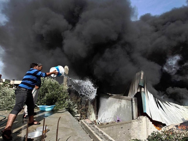 Palstinenser versuchen nach einem isr...Gazastreifens, ein Feuer zu lschen.    | Foto: dpa