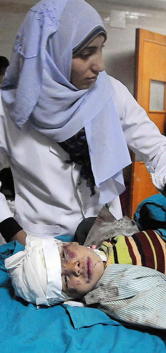 Eine Krankenschwester kmmert sich um ...r bei dem Unglck verletzten Schler.   | Foto: afp