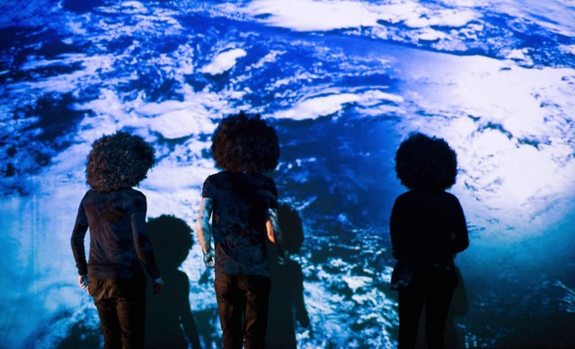 Performance-Knstler mit wilden Percken vor der Projektion des  Globus   | Foto: Gregor Braendli