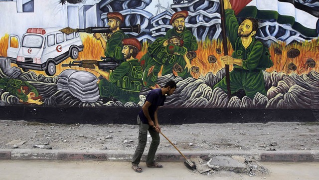 Aufrumarbeiten: Ein palstinensischer...ten Waffenruhe Betonbrocken zusammen.   | Foto: AFP