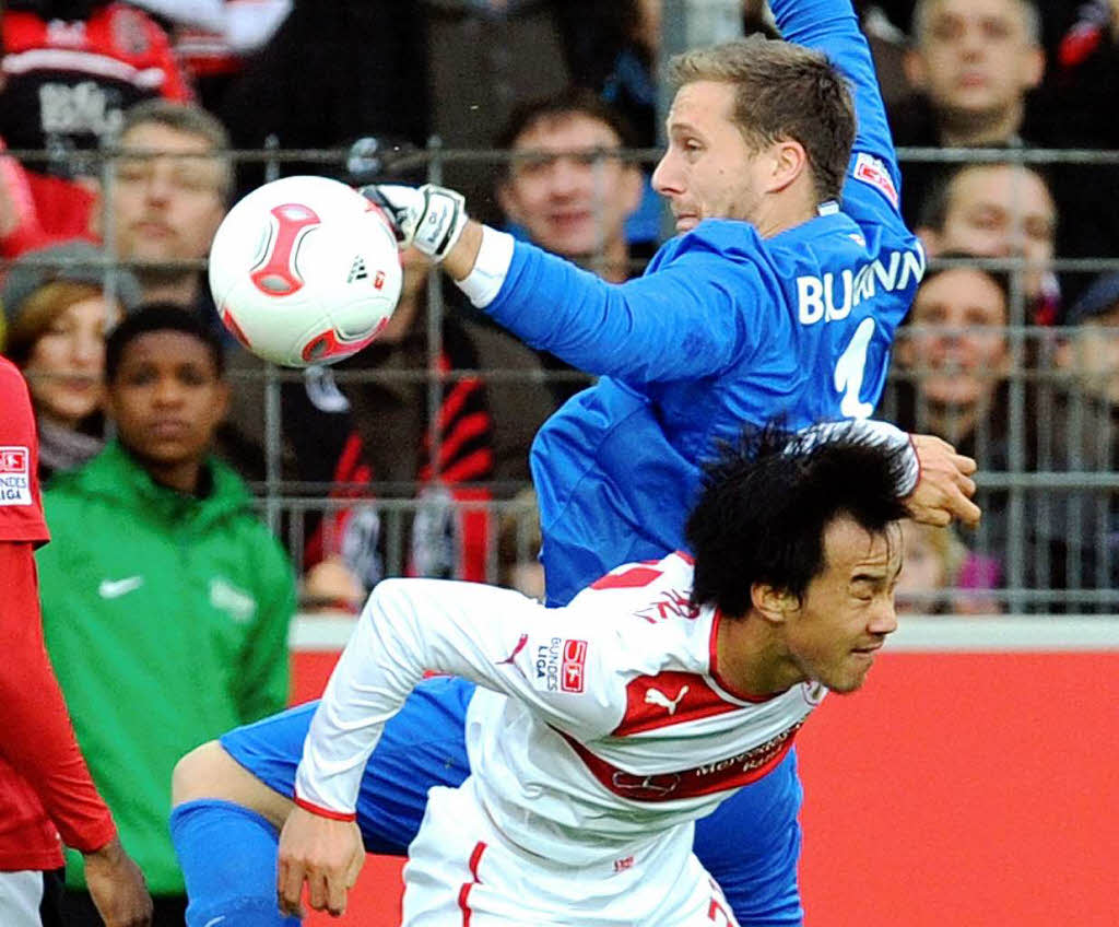 Torwart Oliver Baumann (o) von Freiburg kmpft mit Shinji Okazaki (u) von Stuttgart um den Ball.