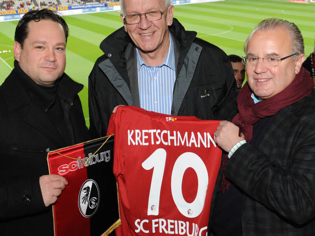 SC-Prsident Fritz Keller (rechts) berreicht Landesvater Winfried Kretschmann ein SC-Trikot mit der Spielmacher-Nummer 10. Landwirtschaftsminister Alex Bonde ist auch dabei.