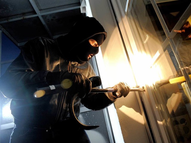 Ein Einbrecher macht sich an einem Fenster zu schaffen (Symbol).  | Foto: dapd