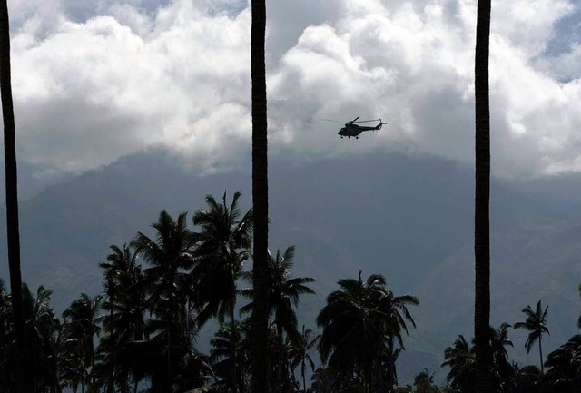 Ein Militrhelikopter sucht ein vom Ta...dlichen Philippinen nach Menschen ab.   | Foto: DPA