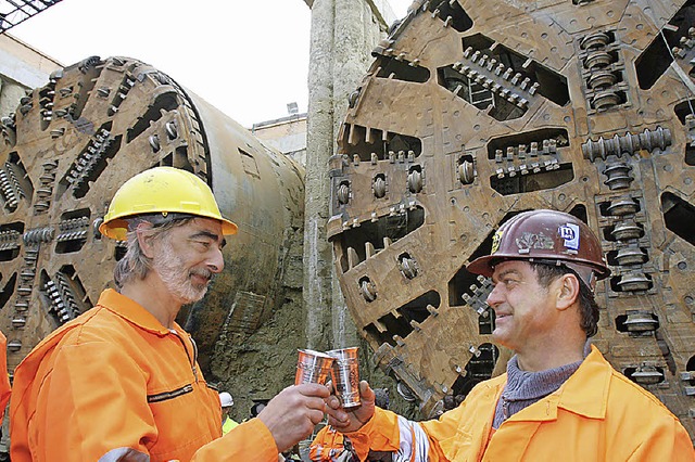 Geschafft: Tunnelbauarbeiter  stoen a...tergrund die  Tunnelvortriebsmaschinen  | Foto: dpa