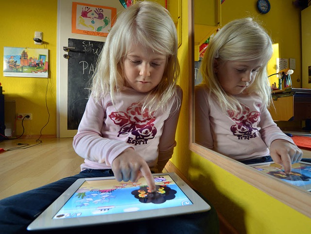 Davon raten Experten ab: Die sechsjhr...m Spielen mit einem Tablet-Computer.    | Foto: Fotos: Torsten Silz (dapd) / Thomas Frey (dpa)