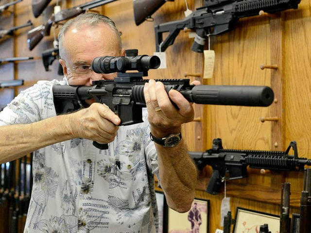 Ein Verkufer in einem US-Waffenladen fhrt seine Ware vor.  | Foto: dpa
