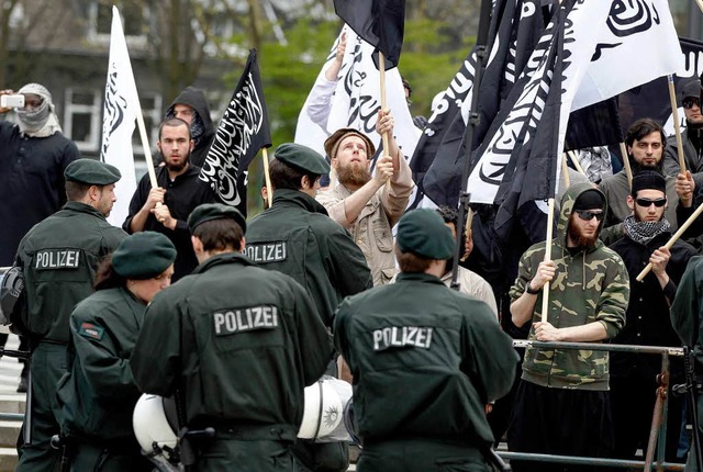 Polizisten stehen in Solingen vor protestierenden Salafisten.  | Foto: dapd