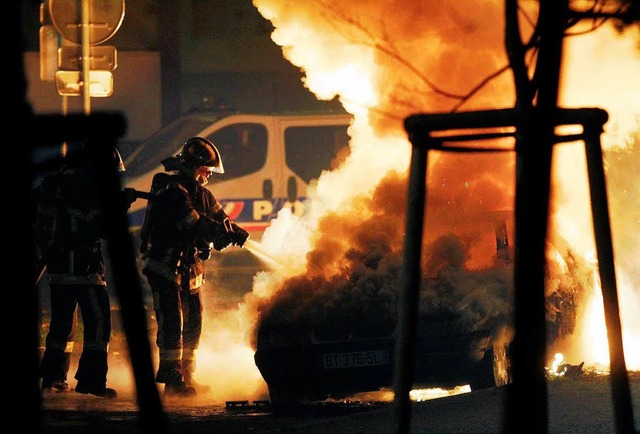 Feuerwehrleute lschen ein brennendes Auto an Silvester in Straburg.   | Foto: Jean-Marc Loos