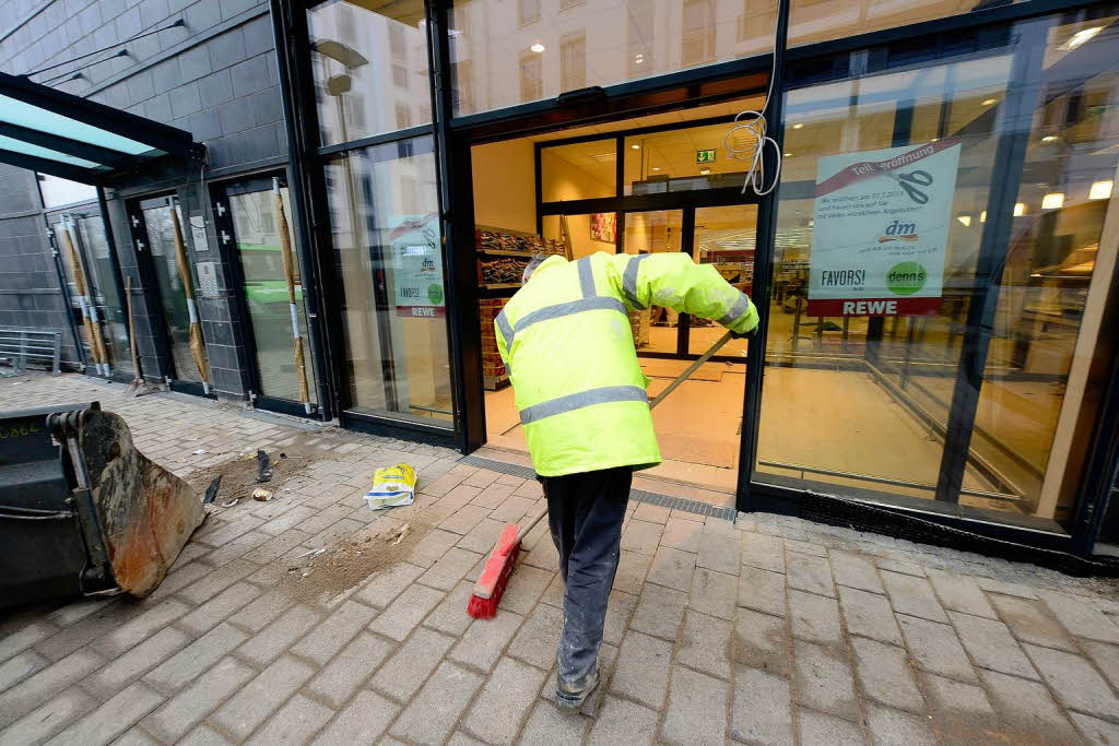 Letzte Arbeiten am Gehwegpflaster vor dem Eingang zu den Geschäften. Letzte Arbeiten am Gehwegpflaster vor dem Eingang zu den Geschäften.
