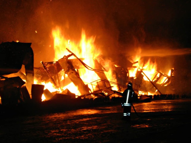 Ein Feuerwehrmann vor dem brennenden Kamelhof.  | Foto: dpa