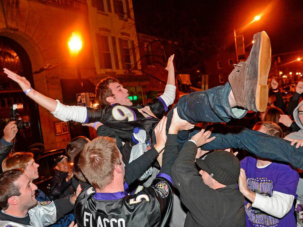 Auf den Straen jubeln die Fans der Baltimore Ravens mit.