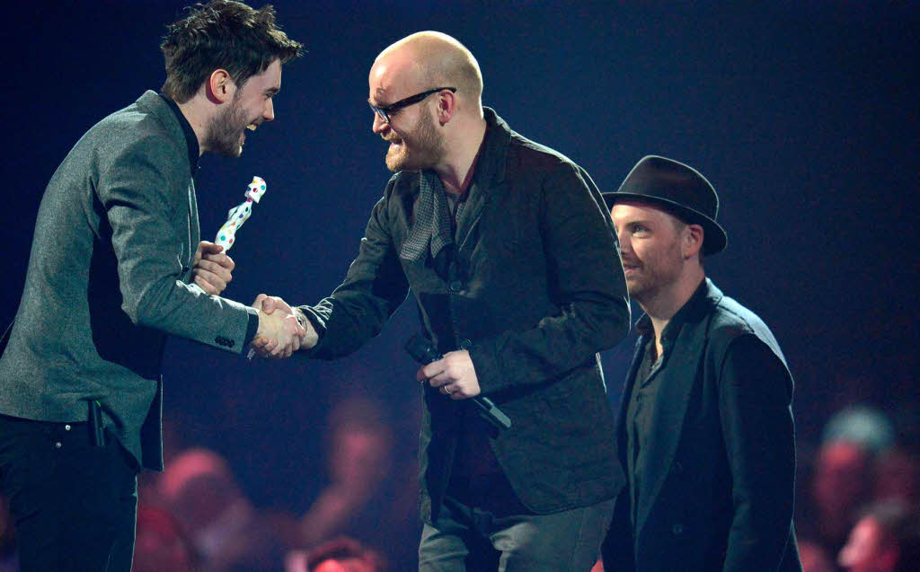 Jonny Buckland (rechts) and Will Champion (Mitte) von Coldplay nehmen den Preis fr den besten Liveknstler entgegen.