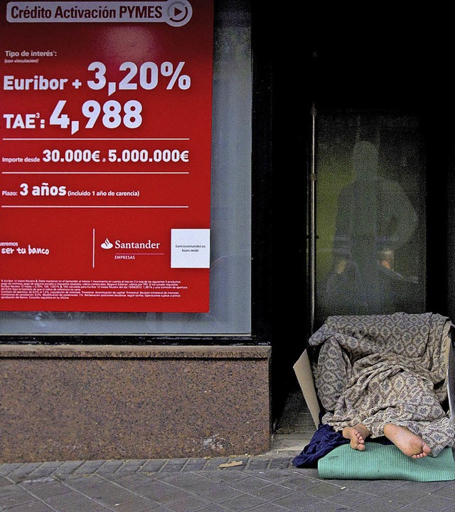 Ein Wohnungsloser schlft im Eingang einer Bank in Madrid.   | Foto: dapd