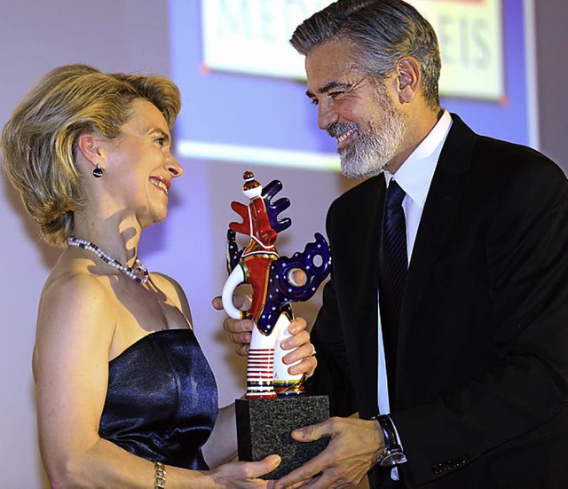 Wer strahlt mehr? Arbeitsministerin Ur...r Leyen berreicht Clooney den Preis.   | Foto: dpa