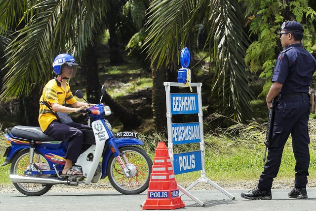 Straensperre der Polizei vor dem besetzten Dorf Lahad Datu   | Foto: dpa