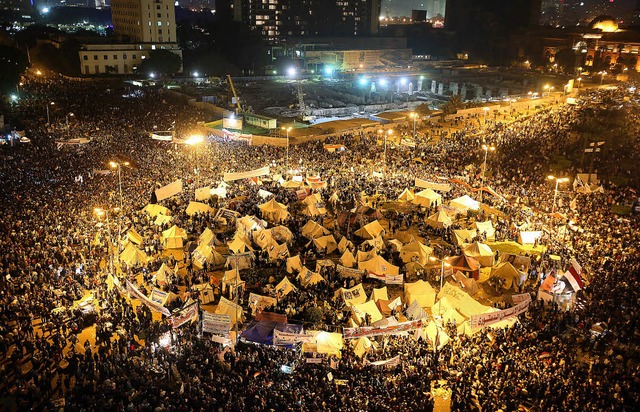 Massen von Jugendlichen demonstrieren auf dem nchtlichen Tahrirplatz in Kairo.   | Foto: dpa (2)/Cedric Rehman