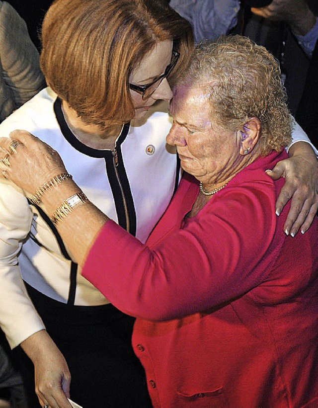 Premierministerin Gillard (links) umarmt eine Betroffene.   | Foto: AFP
