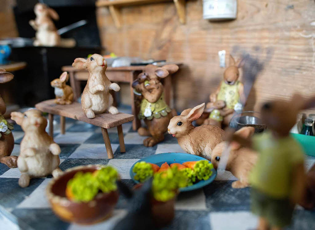 In einem Bauchladen sind Hasenfiguren in einer Miniaturkche zu sehen.