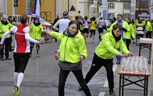 Verpflegung bei Kilometer 16: Sarah (v... die anderen Helfer kommen kaum nach.   | Foto: Thomas Kunz