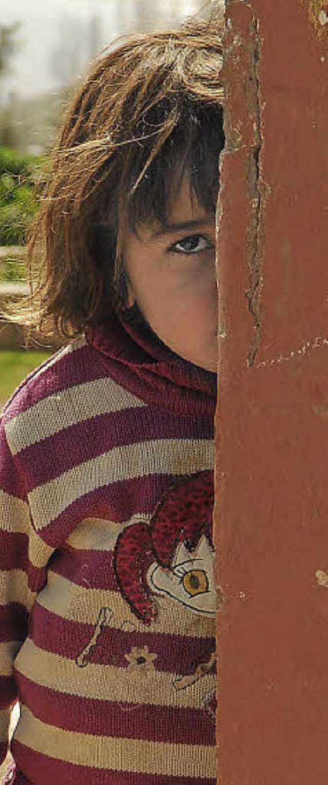 Ein Flchtlingskind schaut in der liba...ebene  hinter einer Huserwand hervor.  | Foto: christian laas